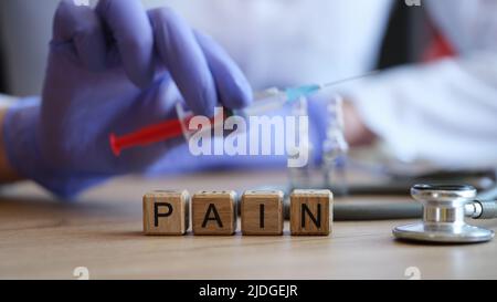 Wortschmerz aus Holzwürfeln in rohem Holz gesammelt Stockfoto