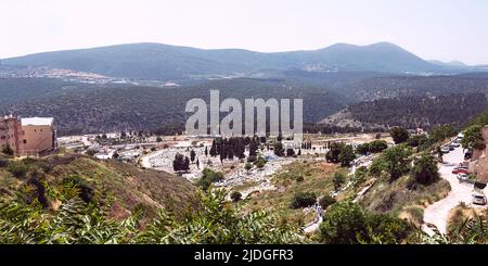 Uralter Friedhof von Tsfat Safed im Obergaliläischen Galil in Israel mit dem Berg Meron und einem trüben blauen Himmel im Hintergrund Stockfoto