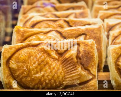 Taiyaki ist ein traditioneller japanischer Fischkuchen, der normalerweise mit roter Bohnenpaste gefüllt ist. Stockfoto