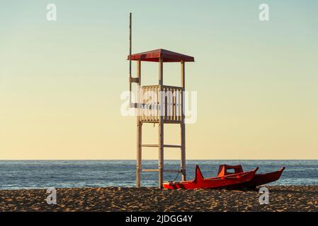 Salvataggio Rettungsschwimmer Wachturm und Rettungsboot am Sandstrand von Piscinas Dünen im goldenen Licht bei Sonnenuntergang, Costa Verde, Sardinien, Italien Stockfoto