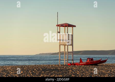 Salvataggio Rettungsschwimmer Wachturm und Rettungsboot am Sandstrand von Piscinas Dünen im goldenen Licht bei Sonnenuntergang, Costa Verde, Sardinien, Italien Stockfoto