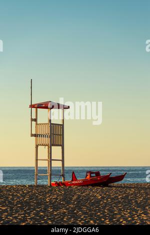 Salvataggio Rettungsschwimmer Wachturm und Rettungsboot am Sandstrand von Piscinas Dünen im goldenen Licht bei Sonnenuntergang, Costa Verde, Sardinien, Italien Stockfoto
