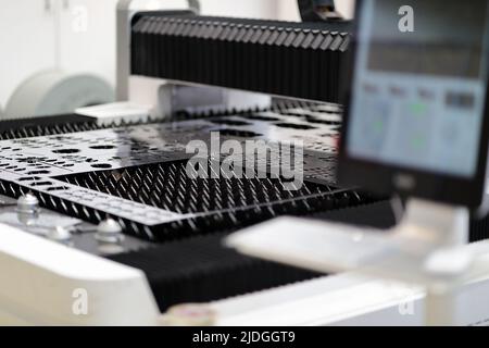 Metallblech auf Arbeitstisch der Laserschneidmaschine. Selektiver Fokus. Stockfoto