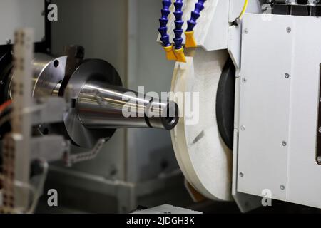 Werkstückbearbeitung mit Schleifscheibe auf Rundschleifmaschine. Selektiver Fokus. Stockfoto