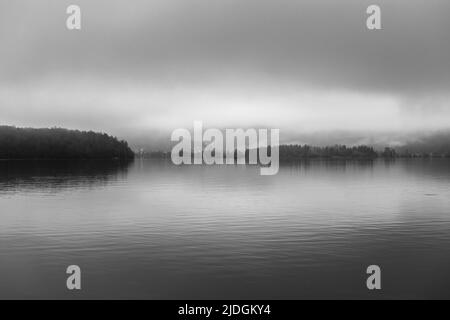 Blick auf den Hallstatter See im Salzkammergut. Wolken und Nebel werden reflektiert. Gmunden. Österreich. Europa. Schwarz-weiße Landschaft. Stockfoto