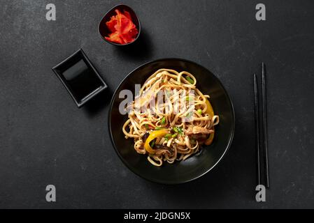 Vegetarische Schezwan Nudeln oder Gemüse Hakka Nudeln oder Chow Mein in schwarz Schüssel am dunklen Hintergrund. Schezwan Nudeln ist indo-chinesischen Küche heiß Dis Stockfoto