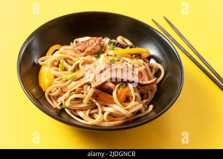 Asiatisch vegetarisch essen Udon Nudeln mit Baby Bok Choy, Shiitake-Pilze, Sesamöl und Pfeffer close-up auf einem Teller auf den Tisch. horizontale Ansicht von oben her Stockfoto