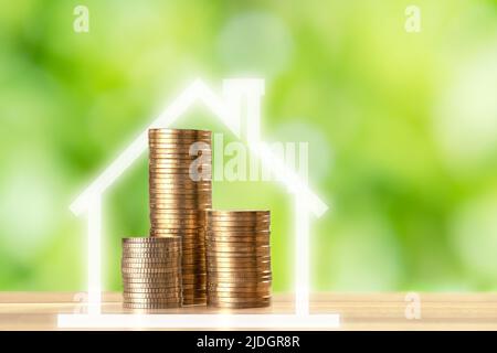 Nahaufnahme von Münzstapeln und Hausform auf unscharfem Hintergrund. Konzept der Investition in Immobilien und Bankkredite oder Hypotheken. Stockfoto