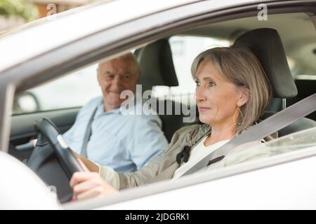 Alter Mann und Frau sitzen im Auto Stockfoto