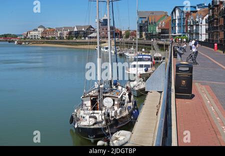 Littlehampton, West Sussex, Großbritannien. Die Yachten liegen am Ostufer des Flusses Arun. Zeigt den Fußweg am Fluss und das Stadtzentrum dahinter. Stockfoto