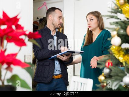 Schuldeneintreiber und Frau vor der Tür Stockfoto