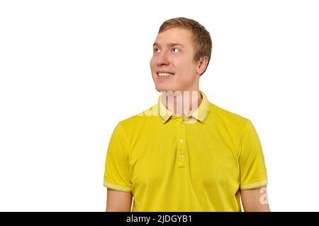 Porträt von lustigen jungen Mann in gelben T-Shirt suchen links isoliert auf weißem Hintergrund. Attraktiver lächelnder Mann mit guten Gefühlen, schöner Happ Stockfoto