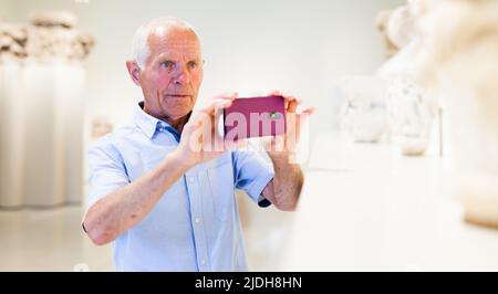 Mann fotografiert Skulpturen im Museum Stockfoto