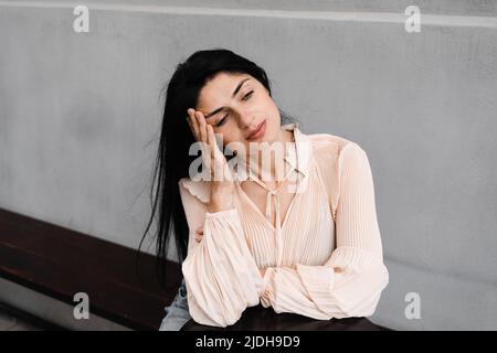 Stress und Kopfschmerzen bei Frau mit Vitiligo Hautpigmentierung an den Händen. Lebensstil mit saisonalen Hauterkrankungen Stockfoto