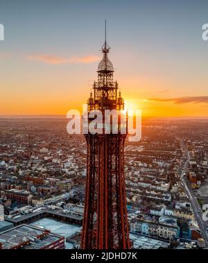 Blackpool, Lancashire, Großbritannien. 20.. Januar 2022. Sunrise schlägt hinter dem Blackpool Tower und über Lancashire. Luftbild. Stockfoto