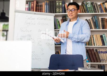 Der Chinesische Lehrer Hat Eine Online-Vorlesung, Die In Der Nähe Des Whiteboards Im Klassenzimmer Steht Stockfoto