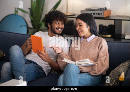 Junger Mann und junge Frau sitzen auf dem Sofa und reden Stockfoto