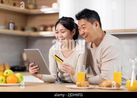 Süßes asiatisches Paar, das von zu Hause aus beim Frühstück einkaufen geht Stockfoto