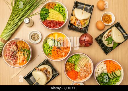 Set aus asiatischen gesunden Gerichten, mit Lachsschüssel, mariniertem Lachs, rotem Thunfisch mit roter Zwiebel und Sauce, Wakame-Algen, edamame-Bohnen, Mexikanisch Stockfoto