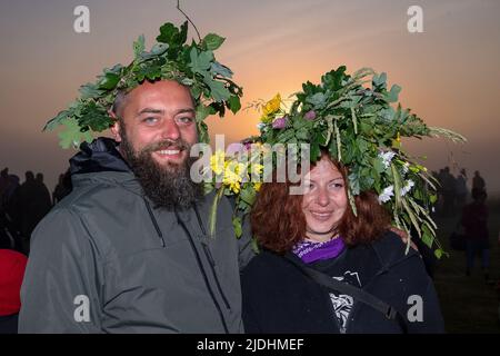 WILTSHIRE, ENGLAND - 21,2022. JUNI: Druiden, Heiden und Nachtschwärmer versammeln sich in Stonehenge in der Hoffnung, den Sonnenaufgang zu sehen, während sie am 21. 2022. Juni in Wiltshire, England, an den Sommersonnenwende-Feierlichkeiten am alten neolithischen Denkmal von Stonehenge in der Nähe von Salisbury teilnehmen. Mehrere tausend Menschen versammelten sich bei Sonnenaufgang am berühmten historischen Steinkreis, einem UNESCO-Weltkulturerbe, um die Sonnenwende zu feiern Stockfoto