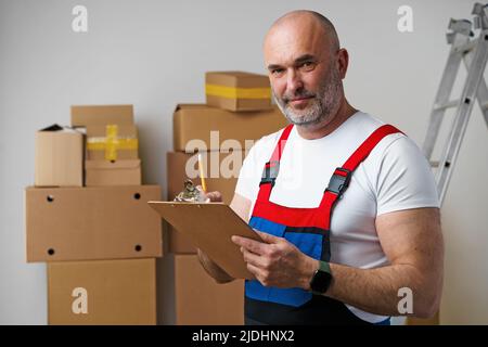 Mann mittleren Alters in Uniform Notizen auf Zwischenablage Stockfoto