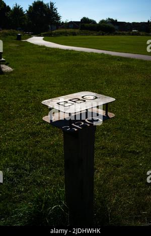 Metall-Grillschutz steht für Einweg-Grills im öffentlichen Park in Eastleigh in der Nähe von Southampton Hampshire England, um Brände und Unfälle zu verhindern. Stockfoto