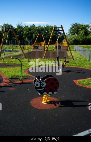 Leerer Kinderspielplatz in der Eastleigh Southampton Parnell Road mit weichen Spielbereichen, federnden Marienkäfer und Seilrutschen. Stockfoto