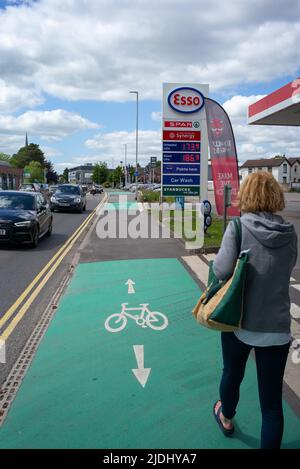 Esso-Tankstelle und Fahrradstraße, die an der A36 Salisbury Wiltshire UK vorbeiführt, zeigt Frauen, die am Verkehr vorbeigehen, und die Tankstelle auf der Fahrradstraße. Stockfoto