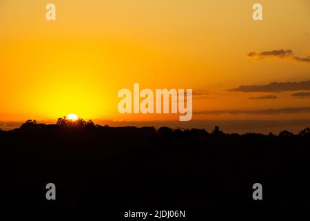 Goiania, Goiás, Brasilien – 19. Juni 2022: Ein wunderschöner goldener Sonnenuntergang am Horizont, von einer Autobahn aus gesehen in der Stadt Goiania. Stockfoto