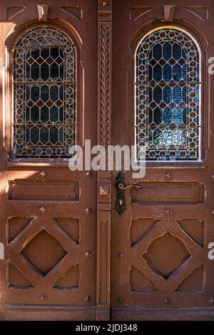 Alte braune Vintage-Türen mit Buntglasfenstern. Stockfoto