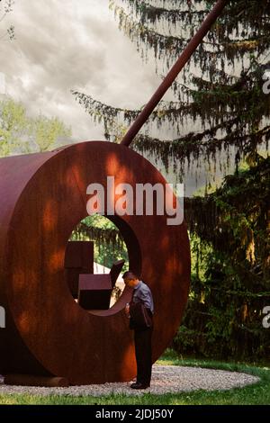 Donut mit 3 Kugeln Skulptur Installation von Fletcher Benton und Besucher im deCordova Skulpturenpark und Museum. Lincoln, Massachusetts, USA. Stockfoto