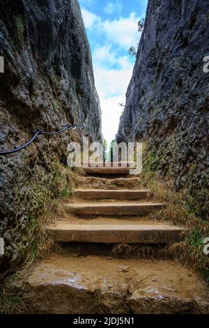 Fußweg mit Stufen zwischen hohen vertikalen Felswänden. Verzauberte Stadt, Cuenca. Stockfoto