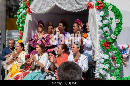 HUELVA, SPANIEN, 2. Juni 2022. Abfahrt der Bruderschaft von Rocío de Huelva durch die Straßen ihrer Stadt. Frauen singen auf der Rückseite eines Wagens Stockfoto