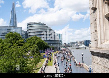 The Queen's Walk am Südufer der Themse in der Nähe der Tower Bridge in London, voll mit ausländischen Touristen und Touristen, die den Tag genießen. Stockfoto