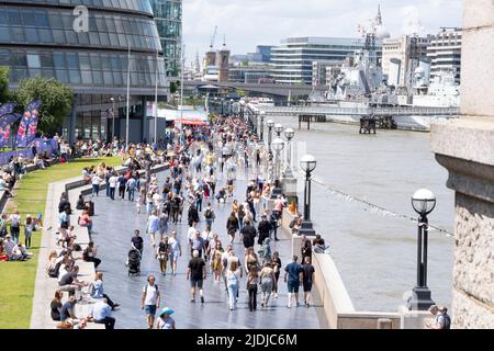 The Queen's Walk am Südufer der Themse in der Nähe der Tower Bridge in London, voll mit ausländischen Touristen und Touristen, die den Tag genießen. Stockfoto