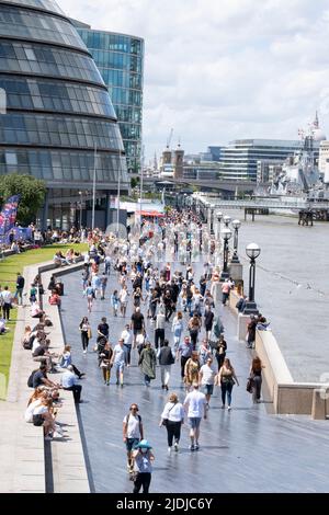 The Queen's Walk am Südufer der Themse in der Nähe der Tower Bridge in London, voll mit ausländischen Touristen und Touristen, die den Tag genießen. Stockfoto