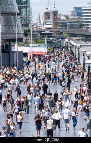 The Queen's Walk am Südufer der Themse in der Nähe der Tower Bridge in London, voll mit ausländischen Touristen und Touristen, die den Tag genießen. Stockfoto