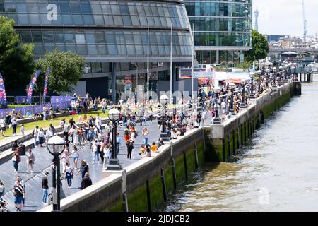 The Queen's Walk am Südufer der Themse in der Nähe der Tower Bridge in London, voll mit ausländischen Touristen und Touristen, die den Tag genießen. Stockfoto