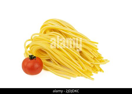 Ein paar Spaghetti und ganze Tomaten zum Kochen auf weißem Hintergrund. Stockfoto