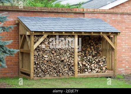 Holzschuppen, großes Blocklager gefüllt mit Brennholz, Holzkonstruktion mit Schieferdach, Großbritannien Stockfoto