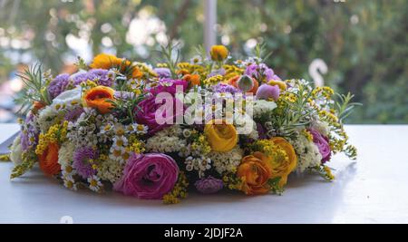 Frauen oder Mütter Tag Feier, Blumenkranz Blumenstrauß Dekoration. Frische bunte Wildblumen und Kräuter auf einem Marmortisch, Nahaufnahme. Frühling, Garten Stockfoto