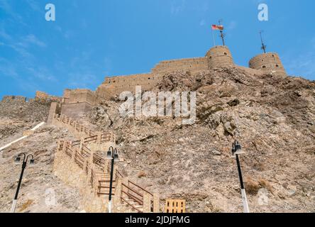 Maskat, Oman - 04.04.2018: Aufnahme einer mittelalterlichen arabischen Festung in der Altstadt von Maskat an einem sehr heißen, sonnigen Tag. Hohe Klippen und Steinmauern. Travelli Stockfoto