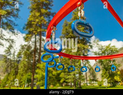 Hängen von Affenbars auf einem Sommerspielplatz in einem Stadtpark. Reihe von blauen hängenden Ringen in einem Park. Straßenfoto, Outdoor-Aktivitäten, verschwommenes Hintergrundbild, Nobo Stockfoto