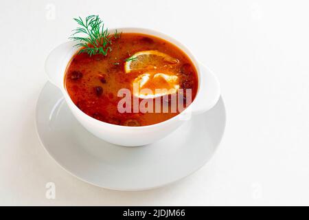 Traditionelle russische Fleischsuppe Soljanka in Schüssel isoliert auf weißem Hintergrund. Ein großartiges Produkt für Ihr Menü. Stockfoto