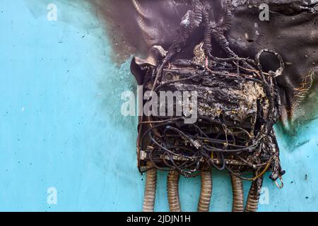 Elektrobrand nach einem Kurzschluss in der Verbrauchereinheit, verbrannte Leitungen und Leistungsschalter in der Schalttafel. Stockfoto