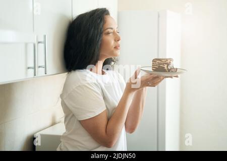 Junge Frau genießt köstlichen Geschmack der Dessert Stockfoto