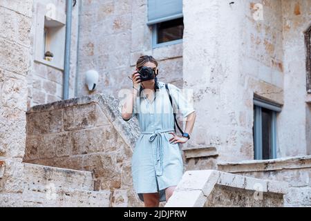 Attraktive blonde junge Frau, die mit der Kamera in der italienischen europäischen Stadt fotografiert, junge Architektin im Urlaub Stockfoto