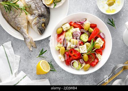 Griechischer Salat, gebackene dorada-Fischbrasse und Tsatziki-Dip. Gesunde Ernährung. Mediterrane Ernährung Stockfoto