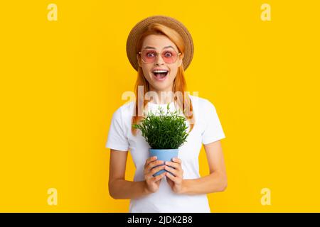 Portrait von wunderschönen Mädchen hält Töpfe mit exotischen Sprossen. Schöne Dame im Garten Outfit lächelnd. Hübsches Modell arbeiten, Sommer Gartenarbeit Konzept Stockfoto