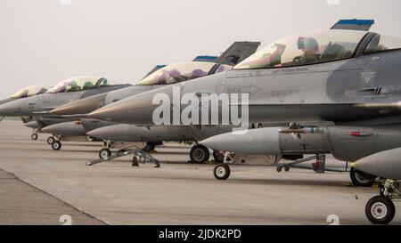 Piloten warten auf die Freigabe zum Taxi zum Start in ihren F-16 Kampffalken, die der 35. Fighter Squadron, Kunstan Air Base, Republik Korea, angehören, als Teil der Übung Red Flag 22-2 auf der Eielson Air Force Base, Alaska, 14. Juni 2022. Das 35. FS, das als „Pantons“ bekannt ist, übernimmt die Luft- und Raumfahrtkontrolle und erzwingt Einsatzaufgaben wie Gegenluft, strategische Angriffe, Verbote und Nahaufnahmen. Es verwendet eine vollständige Palette von Präzisionsanordnungen, kann Tag oder Nacht und bei allen Wetterbedingungen eingesetzt werden. Die Übung mit der Roten Flagge wurde 1975 gegründet und dient als zweiwöchiger Fortschritt Stockfoto